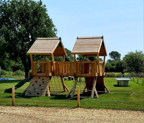 een speeltuin met een houten speelplaats in een park bij The Clifden Arms B&B in Worminghall
