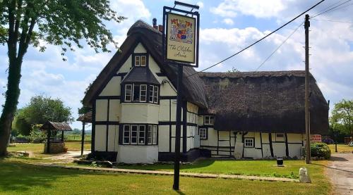 an old building with a sign in front of it at The Clifden Arms B&B in Worminghall