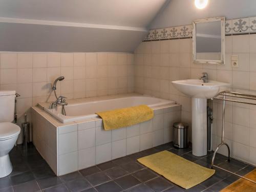 y baño con bañera, lavabo y aseo. en Stunning Chalet in Goé with Swimming Pool, Sauna, Terrace, en Goé