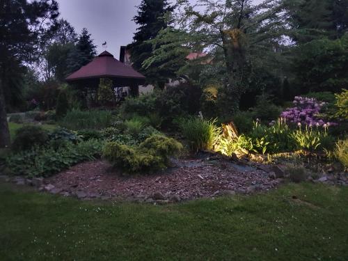 a garden with a gazebo in the background at Gospodarstwo Agroturystyczne Borówkowy Bukiet Smaków in Iwkowa