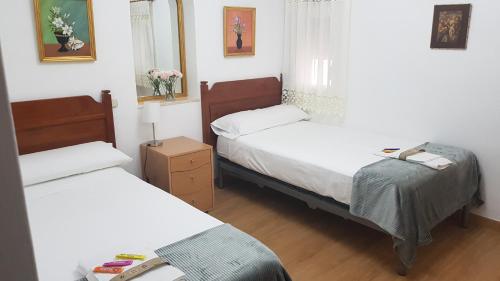 a bedroom with two beds and a mirror at VILLA TONY in Benalmádena