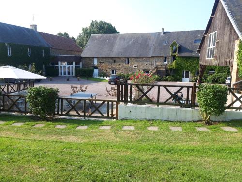a wooden fence with a picnic table in a yard at la ferme des epis in Ouffières