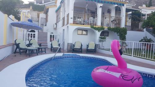 a swimming pool with a pink flamingo in the water at VILLA TONY in Benalmádena