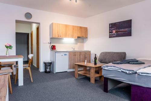 a kitchen and a living room with a couch and a table at Apartmány Summit in Bešeňová
