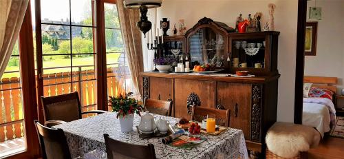 a dining room with a table and a room with a bed at Apartament Vintage in Nowe Bystre