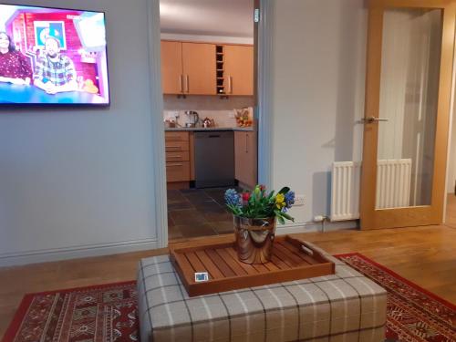 a living room with a vase of flowers on a table at Bishops Park Apartment in Inverness