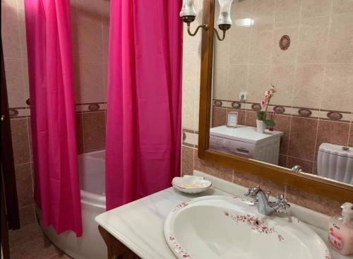 a bathroom with a sink and a pink shower curtain at Appartement de Jerry in Calpe