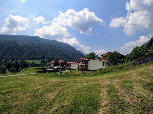 a field with a house and a mountain at Apartments Denis in Tolmin