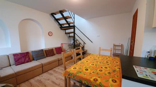 a living room with a couch and a spiral staircase at Littlepanther Balaton in Balatonföldvár