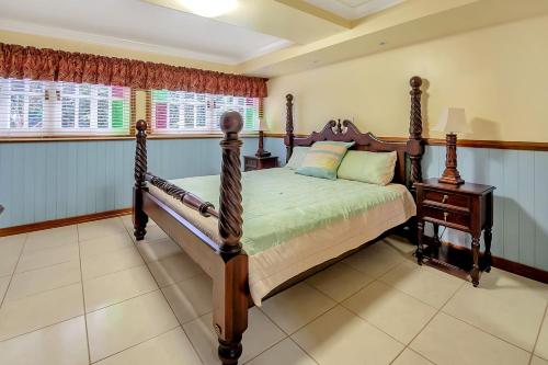 een slaapkamer met een houten bed en een nachtkastje bij Williams Lodge in Yungaburra