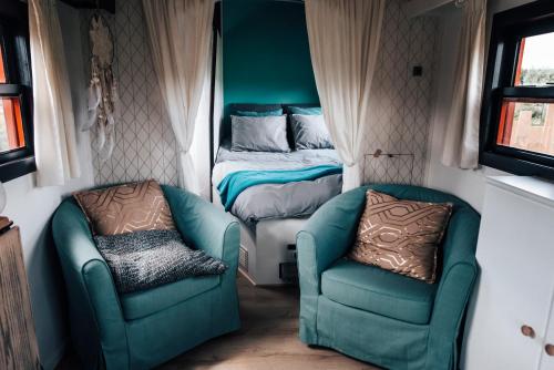 a room with two chairs and a bed and a bed at La vagabonde in Gesves