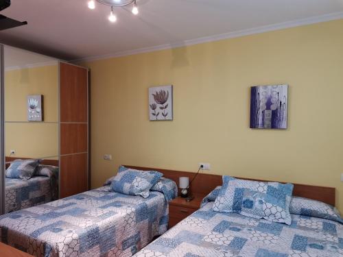 1 dormitorio con 2 camas y 2 cuadros en la pared en Apartamento próximo a Playa Llas, en Foz