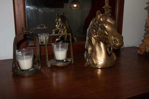 a table with two glasses of milk and a gold horse statue at Quinta do Malhinha- Turismo in Angra do Heroísmo