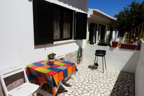 a patio with a table and chairs on a balcony at Casa Lusco Fusco in Carrapateira