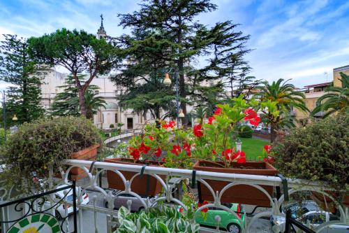 a garden with red flowers on a balcony at Sweet Suite V&V in Pompei