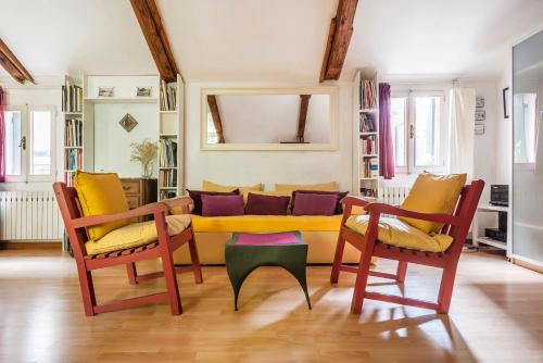 a living room with a yellow couch and two chairs at Ca Lorosa Cosy and comfortable Loft at Castello in Venice
