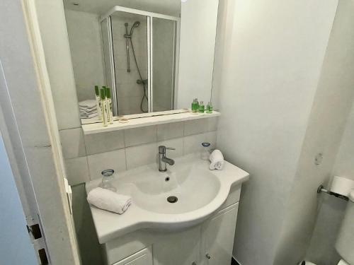 a white bathroom with a sink and a mirror at Studio Nice Centre ville in Nice
