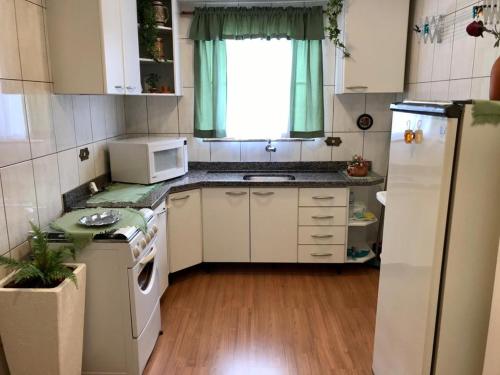 a small kitchen with white appliances and a window at Hospedaria Haus Scharf in Treze Tílias