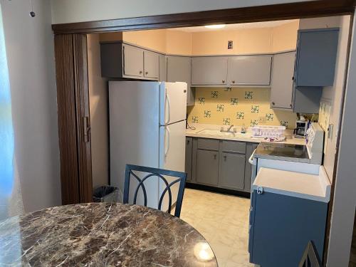 Una cocina con una mesa y un refrigerador blanco. en Diamond Motel - Abilene, en Abilene