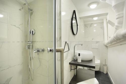 Un baño blanco con ducha y lavabo. en Rent a Room - 2P Passage du Caire, en París