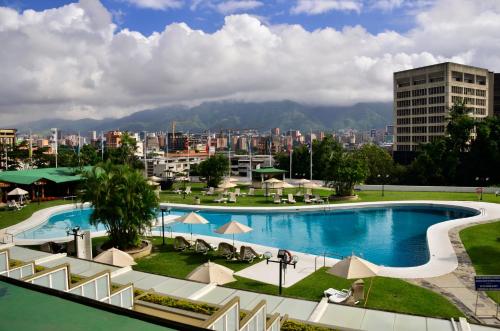 a large swimming pool with a city in the background at Hotel Tamanaco Caracas in Caracas