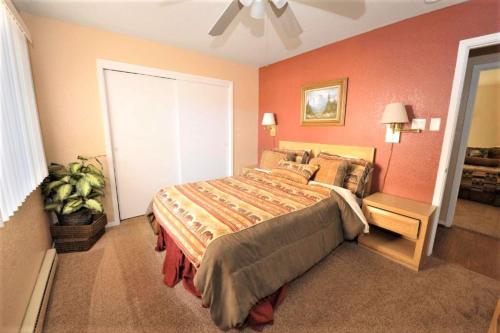 a bedroom with a large bed with orange walls at Pinecliff Village Resort in Ruidoso