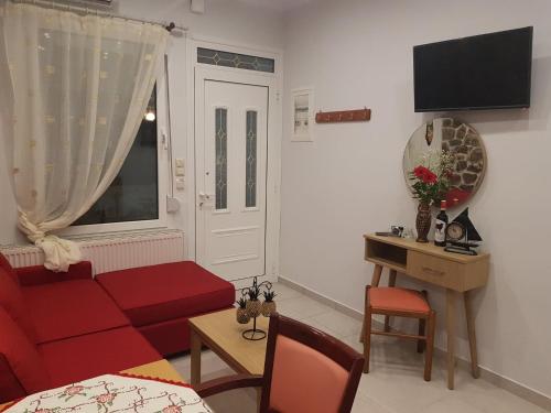 a living room with a red couch and a window at Kohyli Apartments in Skala Rachoniou