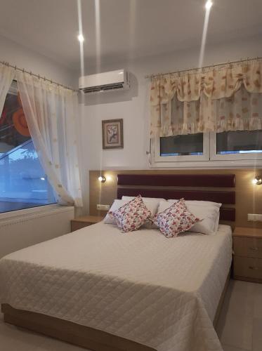 a bedroom with a large bed with two pillows at Kohyli Apartments in Skala Rachoniou