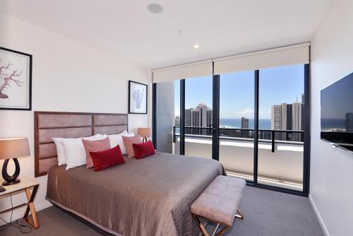 a bedroom with a large bed with a large window at Ruby Gold Coast by CLLIX in Gold Coast