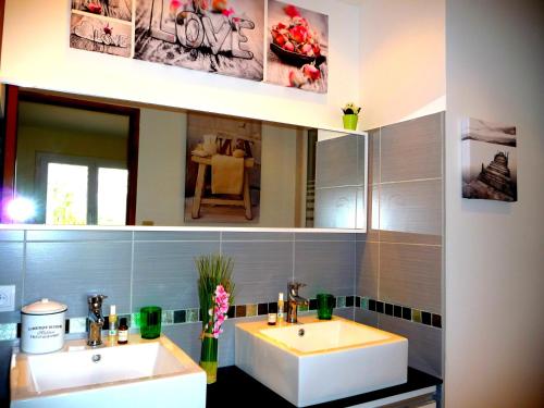 a bathroom with two sinks and a mirror at L'Hermine Occitane B&B in Gratens