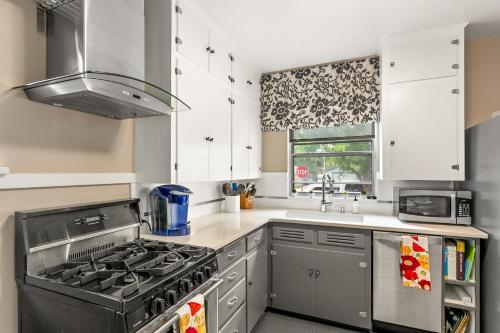 une cuisine avec une cuisinière et un évier dans l'établissement North End Cottage, à Boise