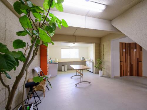 an office with a table and chairs and a plant at Awajishima Hotel Lodge GREEN COZY in Minamiawaji