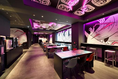 a restaurant with purple lighting and tables and chairs at HOTEL TAVINOS Asakusa in Tokyo