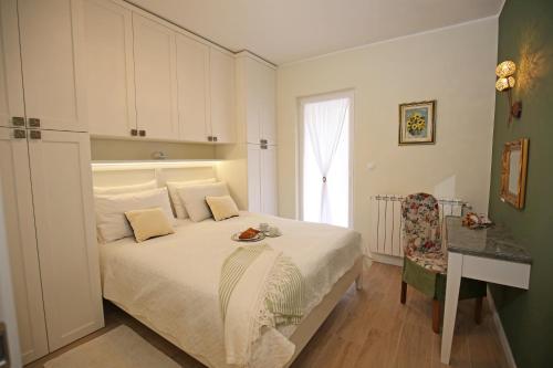 a bedroom with a bed and a table and a window at Apartments Paola in Rovinj