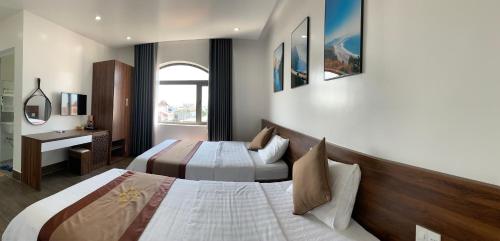 a hotel room with two beds and a window at Win Win Hotel - Khách Sạn Hải Phòng in Hai Phong