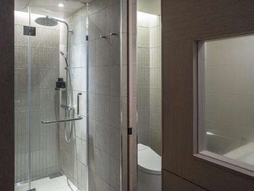 a bathroom with a shower with a glass door at Zentis Osaka in Osaka
