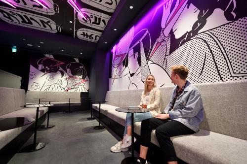a man and woman sitting in a waiting room at HOTEL TAVINOS Asakusa in Tokyo