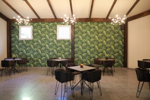 a room with tables and chairs and a green wall at The Herbert Tel Aviv in Tel Aviv