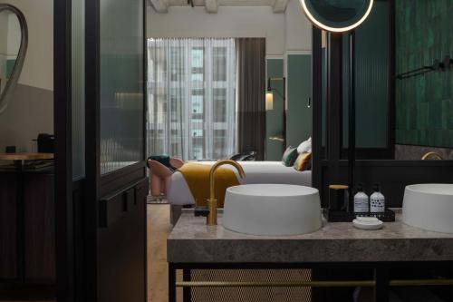 a hotel room with a bed and a mirror at QT Auckland in Auckland