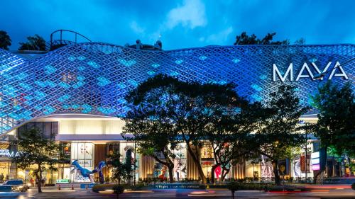 a shopping mall with a blue facade at night at Chor Chang House in Chiang Mai