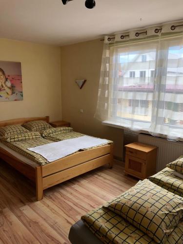 a bedroom with two beds and a window at U Pauli i Eryka in Łeba