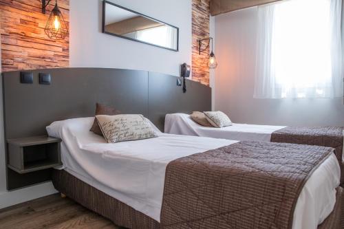 Postel nebo postele na pokoji v ubytování Logis Hôtel - Auberge du Pastel - Hôtel 3 étoiles et Restaurant