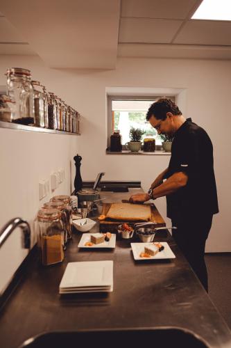 a man standing in a kitchen preparing food at Berghotel Rehlegg in Ramsau