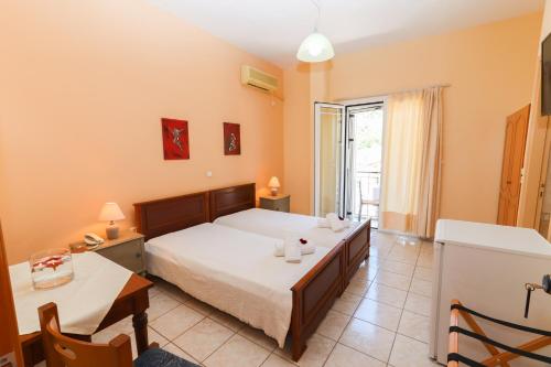 a bedroom with a bed and a table and a window at Angela in Loutra Edipsou