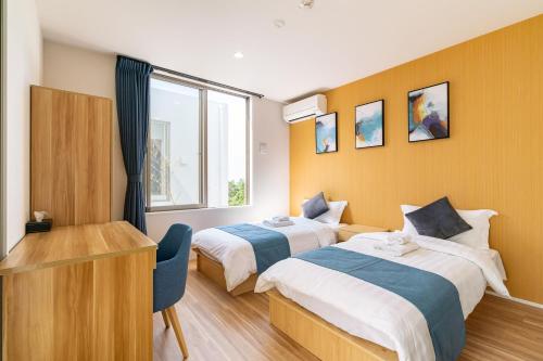 een hotelkamer met 2 bedden en een bureau bij Ocean Villa Fuchaku Okinawa in Fuzuchi