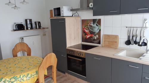 cocina con mesa, fogones, mesa y sillas en Apartment Halmis FeWo WR, en Wernigerode