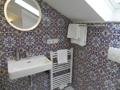 a bathroom with a sink and a mirror at Milchhaus Zimmer - Tiny House in Balingen