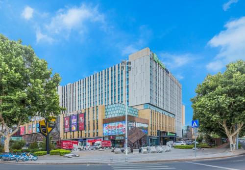 wysoki budynek na ulicy w mieście w obiekcie Holiday Inn Express Qingdao Chengyang Central, an IHG Hotel w mieście Qingdao