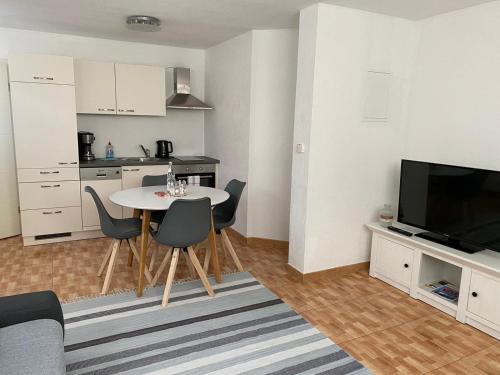 ein Wohnzimmer mit einem Tisch und einer Küche in der Unterkunft Stiller Hafen in Herbolzheim
