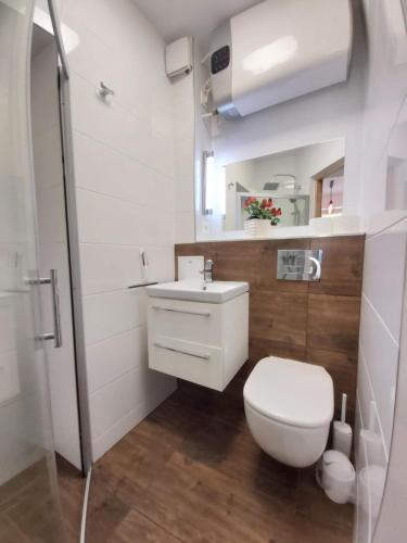 a bathroom with a white toilet and a sink at calkowicie odnowiona kawalerka - czystość, cisza, spokój in Gdynia